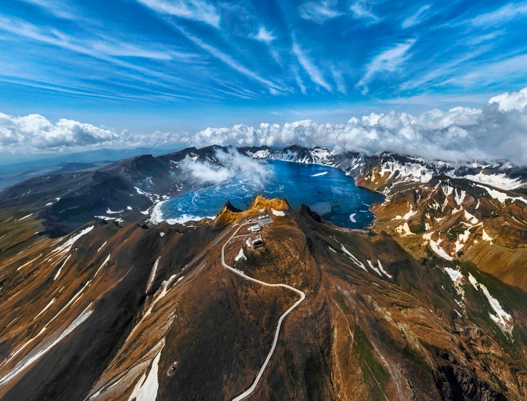 《初夏天池》2022.6拍摄于天池。每年6月中旬，大地己进入伏天，可冰封近200天的长白山天池才逐渐开化，形成美丽的美景，碧蓝的湖水像一块瑰丽的碧玉镶嵌在群峰之中。