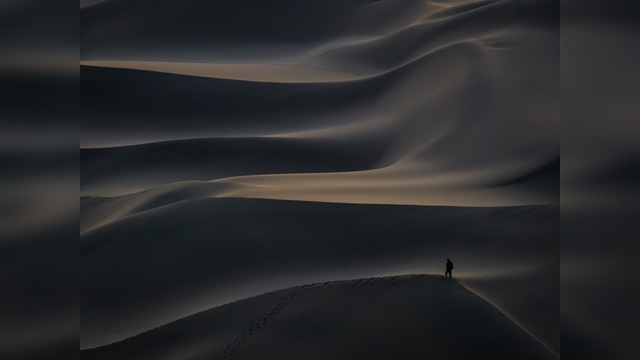 《独行沙海》

在航拍的长焦视角下，清晨的库木塔格沙漠如海洋般汹涌。