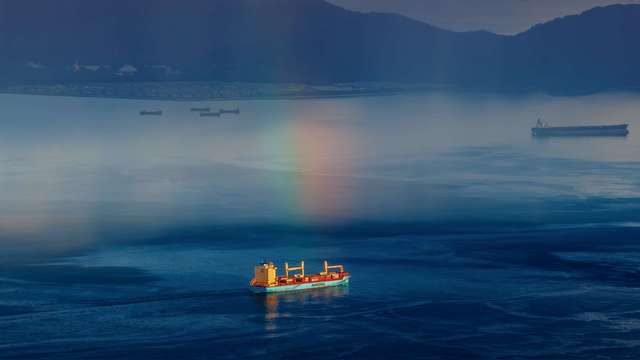 《虹下行驶》 2022年7月25日，中国香港。顺光方向，太阳照到雨幕形成了彩虹。