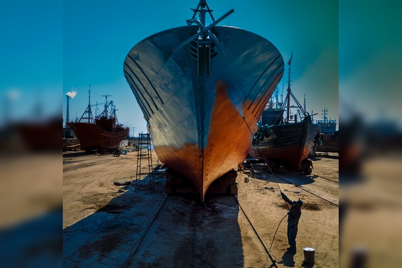《大船美容师》国伏
2023.4月拍摄于辽宁东港修船码头，疫情过去了，船只都要进行检修美化，这是即将出海的船只，青年油漆工正在给大船喷漆作业。