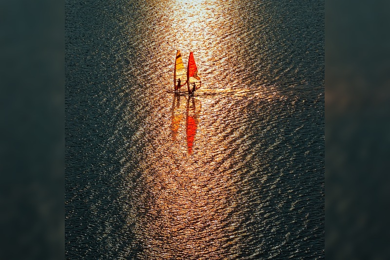 《蜻蜓》 2022年8月28日，夕照时分，安徽芜湖长江之畔的龙窝湖，光影中的两只帆板恰似蜻蜓掠过水面。