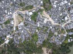 《客家围屋》2025年1月31日，位于广东省潮州市饶平县荔林村，破旧不堪的客家围屋用航拍视角下的呈现出一台巨型自行车。