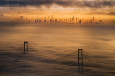 《横卧伶仃洋》2025年3月3日，日出时分的鹏城，云海弥漫，地标建筑若隐若现，深中通道横卧伶仃洋之上，在晨光的照耀下构成了一幅绝美的湾区画卷。